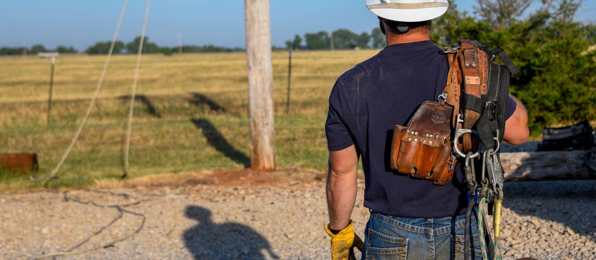 Linemen preparing to climb a power pole