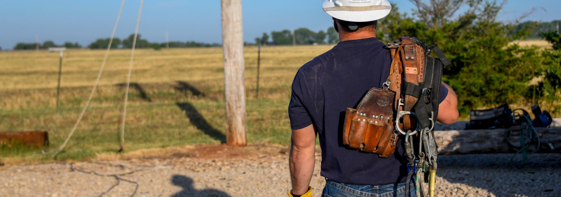 Linemen preparing to climb a power pole